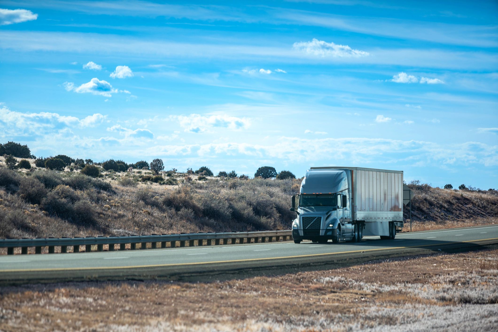 Semi-truck hauling a dry van trailer on an open highway